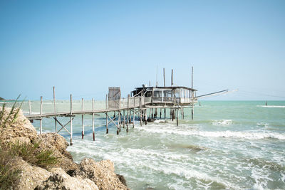 Bridge over sea against clear sky