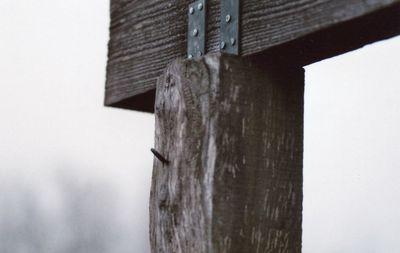 Low angle view of wooden poles in sea against sky