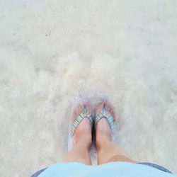 Low section of woman standing on beach