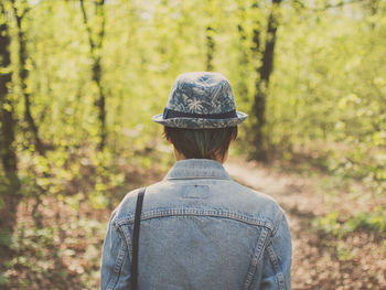 Rear view of woman standing in forest