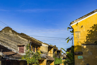 Low angle view of buildings against clear blue sky