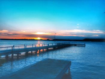 Pier on sea at sunset