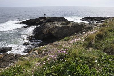 Scenic view of rocks on sea against sky