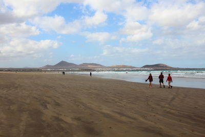 People at beach against sky