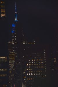 Illuminated cityscape against sky at night