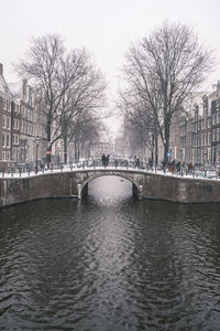 Bridge over river amidst buildings in city