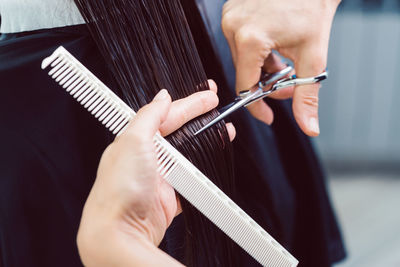 Closeup on hairdresser cutting client's hair