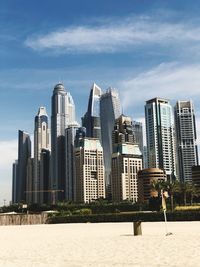 Buildings in city against cloudy sky