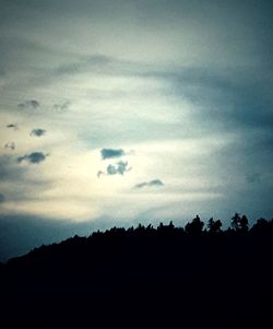 Silhouette trees on landscape against sky at sunset