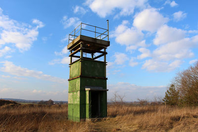 View of field against cloudy sky