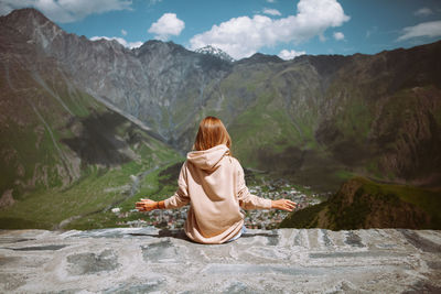 Young woman sitting back and looking for the mountains