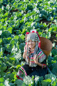 Woman wearing hat holding plant