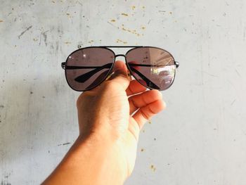 Close-up of hand holding sunglasses