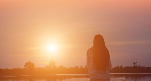 Rear view of silhouette man standing against sky during sunset