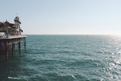 Palace pier by sea against clear sky on sunny day