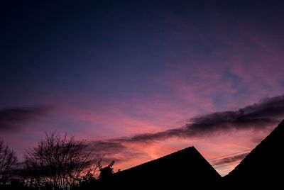 Low angle view of silhouette trees against sky