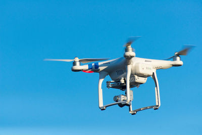 Quadcopter flying in clear blue sky