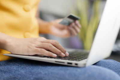 Midsection of man using mobile phone