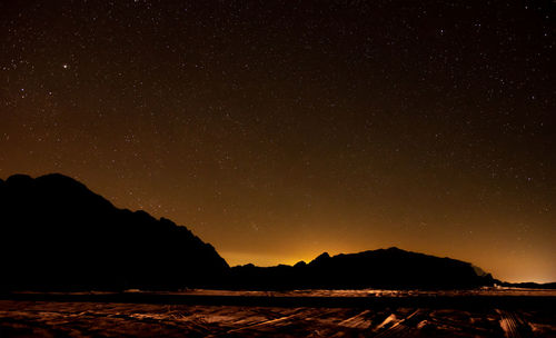 Scenic view of silhouette mountains against sky at night