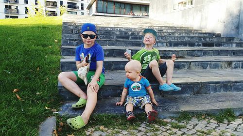 Full length of siblings sitting on steps