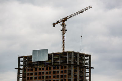 Low angle view of crane against sky