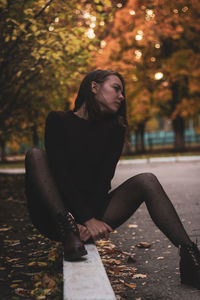 Sensuous woman looking away while sitting on street