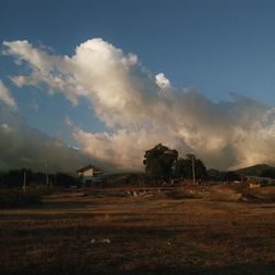 Scenic view of field against cloudy sky