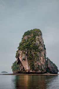 Rock formations by sea against sky