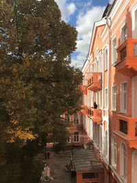 Houses amidst trees and buildings against sky