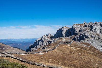 Scenic view of rocky mountains against blue sky