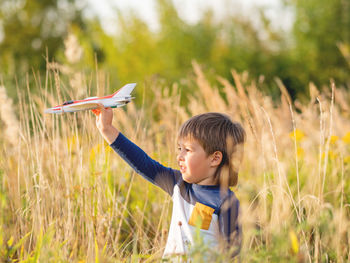 Cute boy playing with toy in grassy field