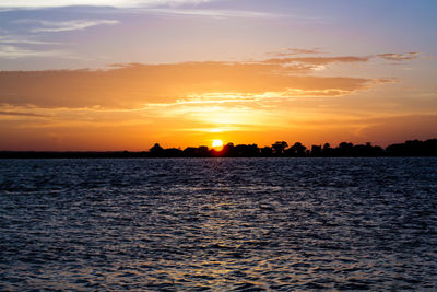 Scenic view of sea against dramatic sky during sunset