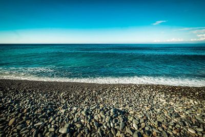 Scenic view of beach against blue sky