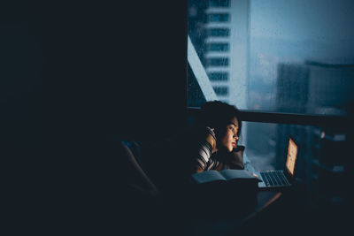 Woman using laptop while lying at home