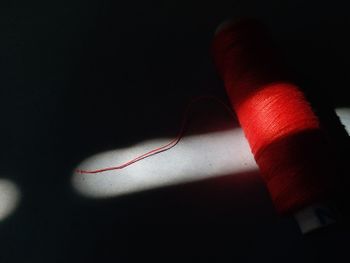 Close-up of red light painting on table against black background