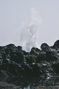 Water splashing in sea against clear sky