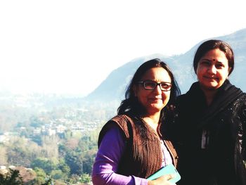 Portrait of woman with mother standing against mountain