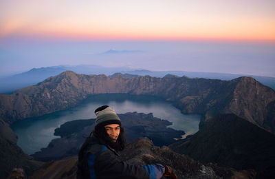 Portrait of man in mountains against sky during sunset