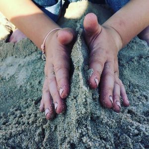 Low section of boy making sandcastle at beach