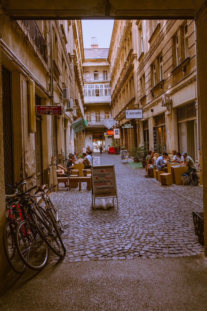 BICYCLES PARKED ON STREET AMIDST BUILDINGS IN TOWN