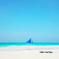 Scenic view of beach against clear blue sky