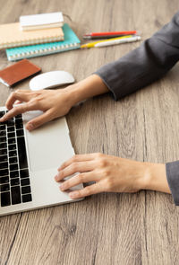 Midsection of man using mobile phone on table