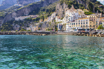 Scenic view of sea by buildings in town