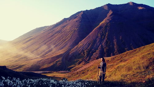 View of man walking on mountain against sky