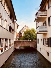 Canal amidst buildings against sky