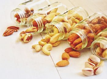 Close-up of dried fruits spilling from jars on table