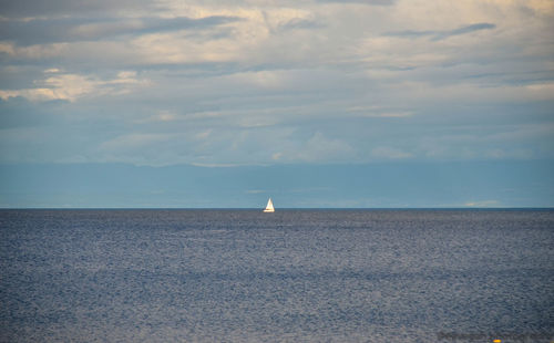 Sailboat in sea against sky