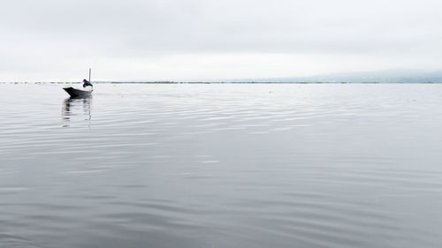 Boat moving on sea against cloudy sky