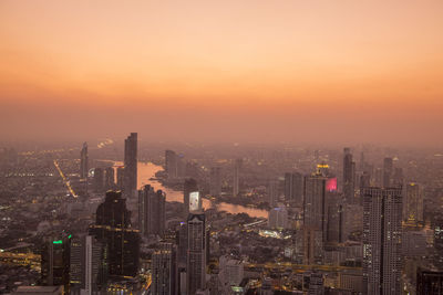 Aerial view of buildings in city during sunset