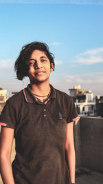 Portrait of teenage girl standing against sky